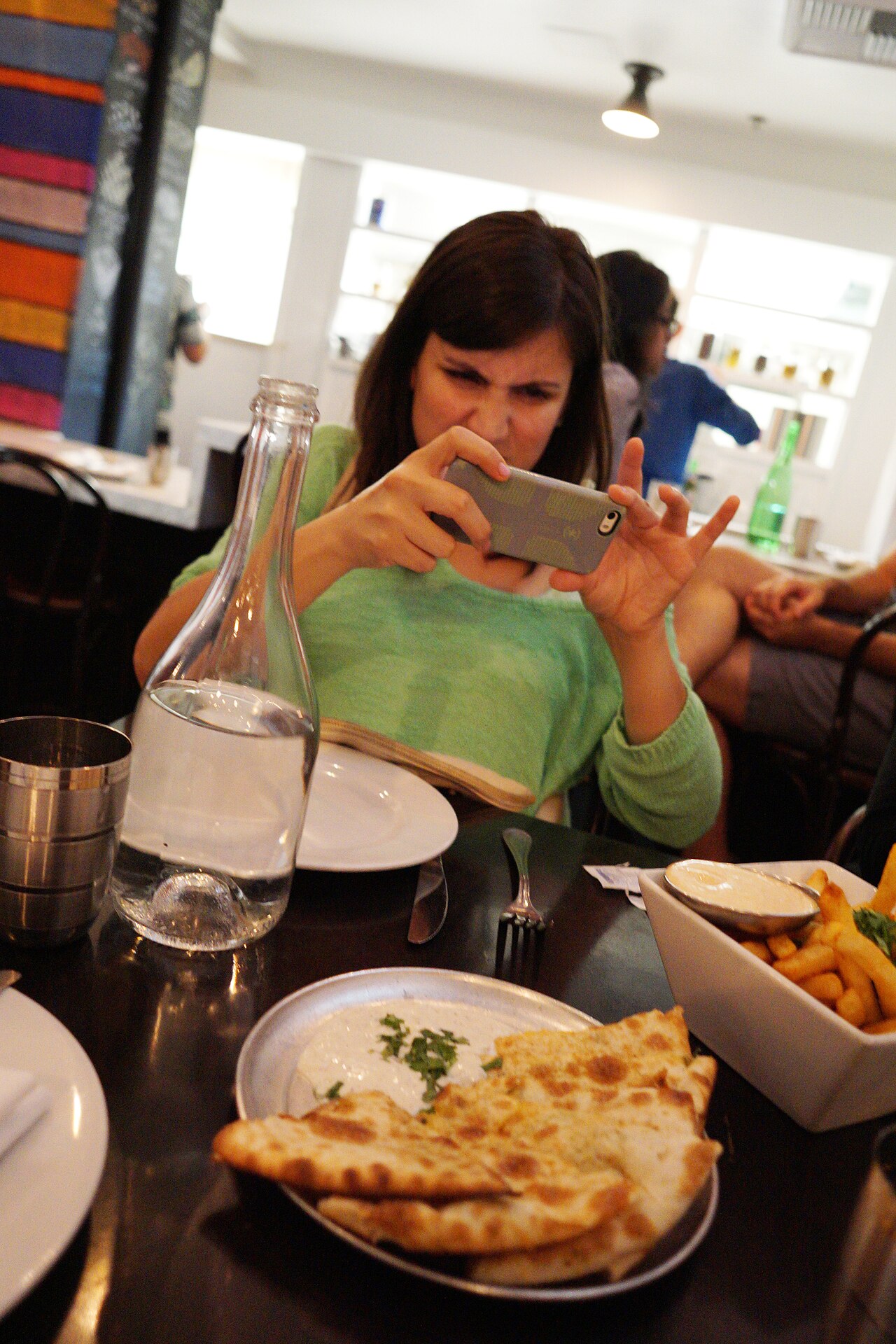 A guest photographing her food before eating at a restaurant