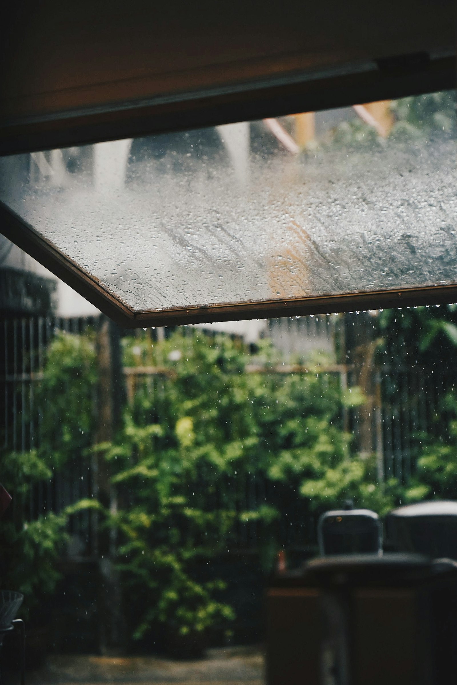 Monsoon rain outside a window, the kind of evening cancellation policies should plan for