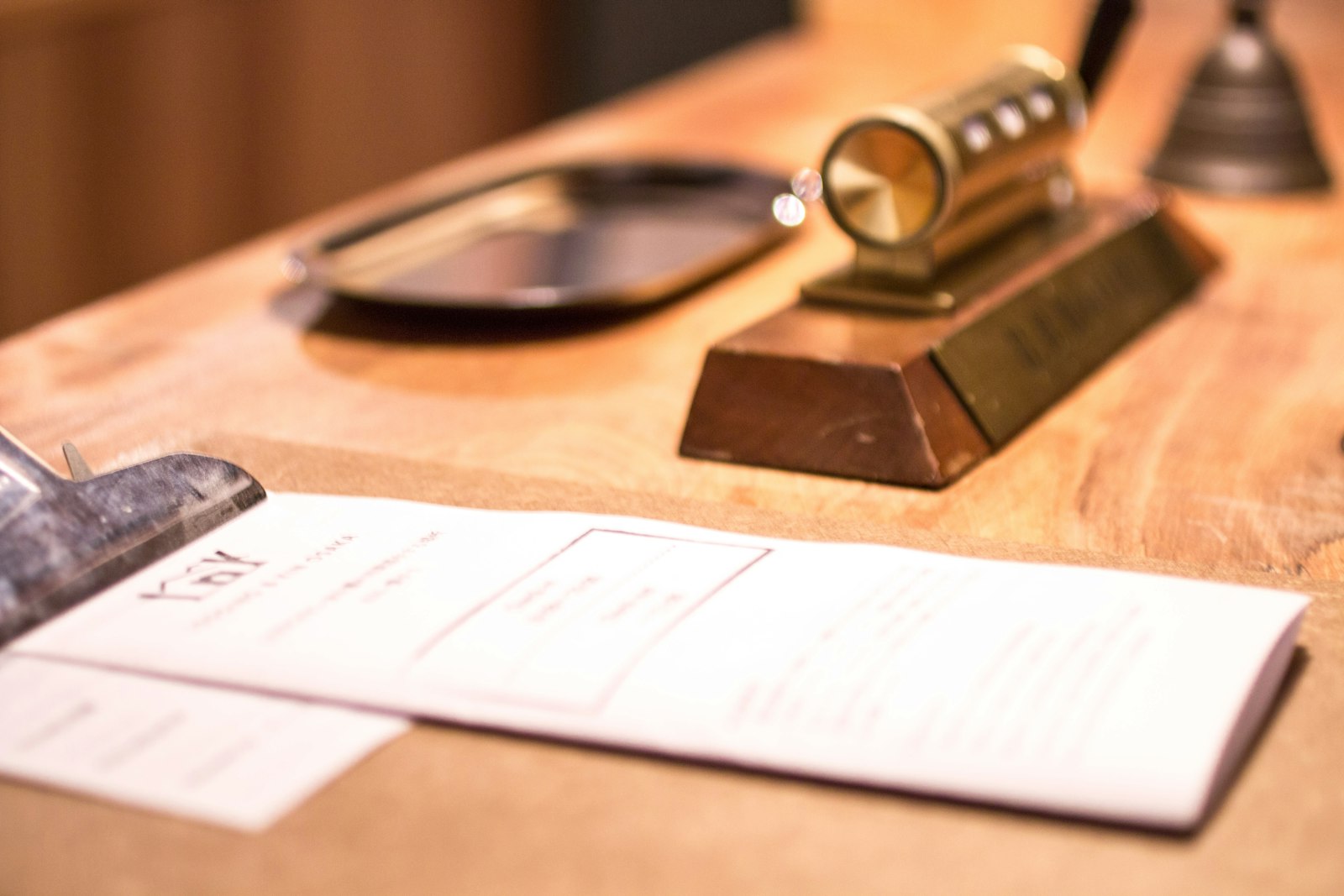 Reception desk of a small hotel with registration slip, stamp and bell
