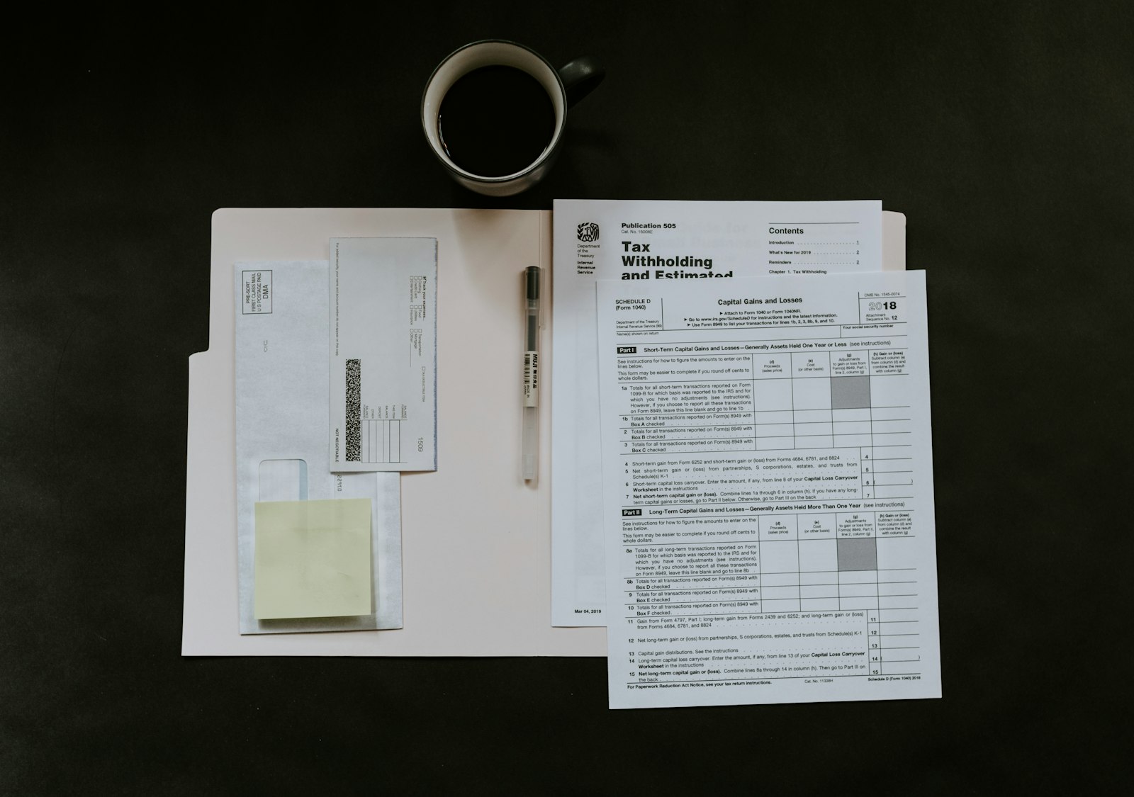 Tax forms and coffee on a desk, representing TDS compliance for hotel room rent
