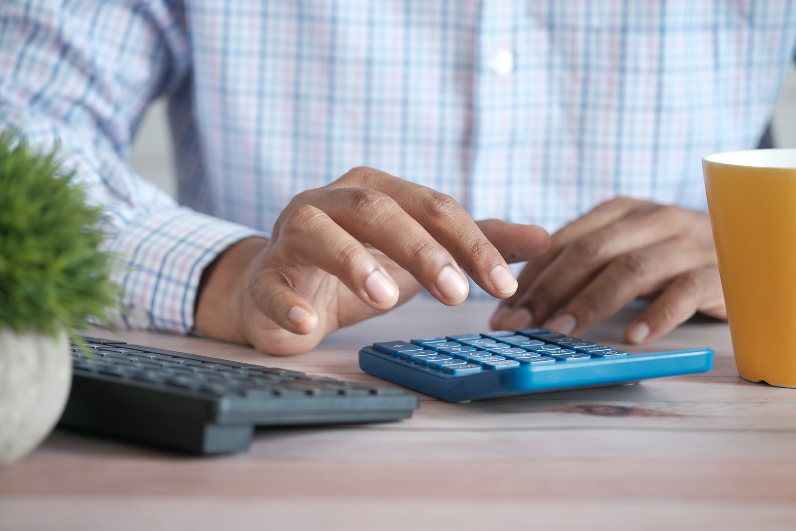 GST Composition Scheme for Small Hotels and Homestays 1 A small business owner using a calculator to work out GST composition scheme turnover limits for a hotel or homestay